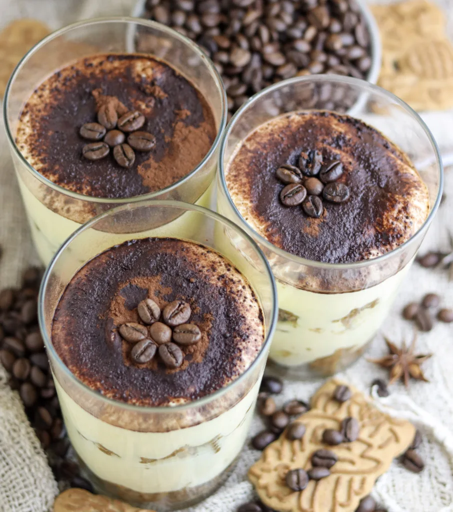 Thee speculoos tiramisu cups sprinkled with cocoa and roasted coffee seeds that look like flowers